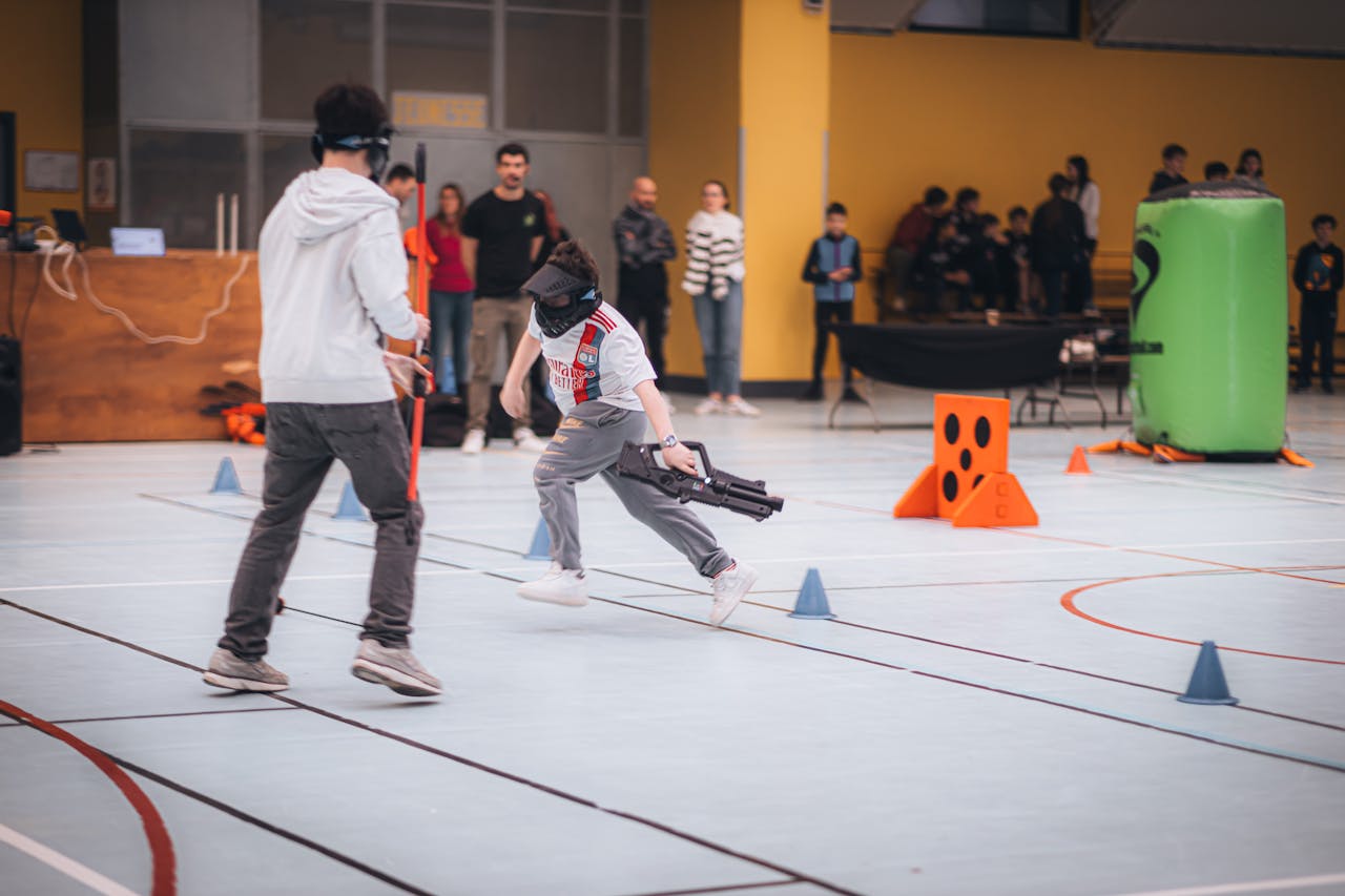 Children engaged in an exciting indoor laser tag game with various obstacles and props.